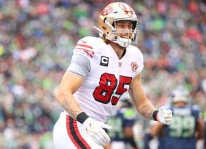 George Kittle #85 of the San Francisco 49ers celebrates after catching the ball for a touchdown during the first quarter against the Seattle Seahawks at Lumen Field on December 05, 2021 in Seattle, Washington.