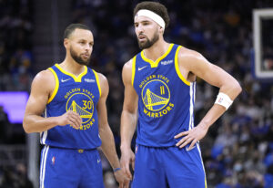 Klay Thompson (right) and Stephen Curry (left) of the Golden State Warriors talks with each other against Indiana Pacers during the first half of an NBA basketball game at Chase Center on January 20, 2022 in San Francisco, California.