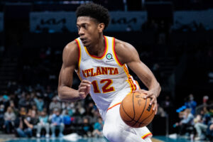 De'Andre Hunter #12 of the Atlanta Hawks brings the ball up court against the Charlotte Hornets during their game at Spectrum Center on January 23, 2022 in Charlotte, North Carolina.