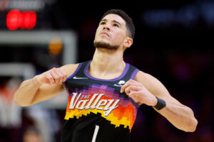 Devin Booker #1 of the Phoenix Suns adjusts his jersey during the second half of the NBA game against the Brooklyn Nets at Footprint Center on February 01, 2022 in Phoenix, Arizona. The Suns defeated the Nets 121-111.