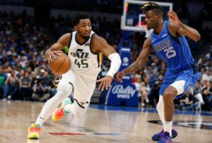 Donovan Mitchell #45 of the Utah Jazz drives to the basket against Reggie Bullock #25 