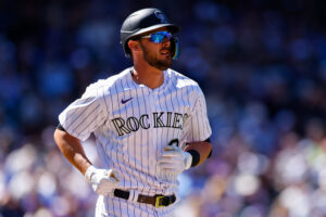 Kris Bryant #23 of the Colorado Rockies jogs to first base with a walk in the first inning against the Los Angeles Dodgers on Opening Day at Coors Field on April 8, 2022 in Denver, Colorado.