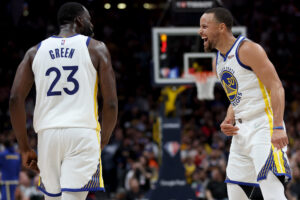 Golden State Warriors Draymond Green, left, and Stephen Curry look at each other in celebration during their victory over the Denver Nuggets on April 21, 2022, in Denver.