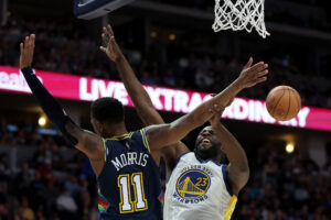 Golden State Warriors forward Draymond Green, right, collides under the basket with Denver Nuggets guard Monte Morris, sending the ball flying out of Morris' grasp, on Sunday, April 24, 2022, in Denver.