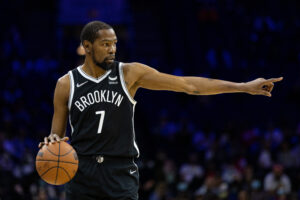 Brooklyn Nets forward Kevin Durant dribbles the ball with his right hand and points with his left