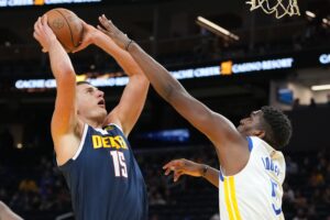 Denver Nuggets center Nikola Jokic takes a shot over an opponent