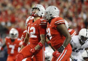 Ohio State Buckeyes safety Lathan Ransom celebrates a sack of Penn State Nittany Lions quarterback Sean Clifford with defensive end Zach Harrison in a game against Penn State