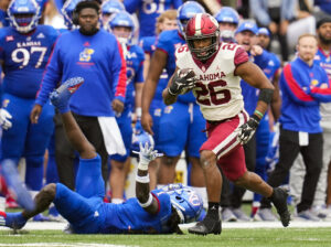 Oklahoma Sooners running back Kennedy Brooks runs against Kansas Jayhawks safety Kenny Logan Jr.