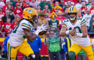 Green Bay Packers quarterback Jordan Love (right) pitches the ball to running back Aaron Jones (left) against the Kansas City Chiefs