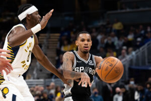 San Antonio Spurs guard Dejounte Murray passes the ball while Indiana Pacers forward Justin Holiday defends