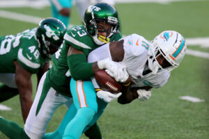 New York Jets cornerback Arthur Maulet (left) tackles Miami Dolphins wide receiver DeVante Parker (right)