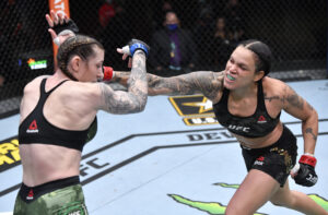 Amanda Nunes (right) lands a punch to the face of Megan Anderson (left) in their UFC featherweight championship fight during the UFC 259 