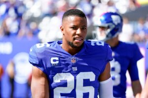 New York Giants running back #26 Saquon Barkley looks on from the sideline in a 2021 home game.