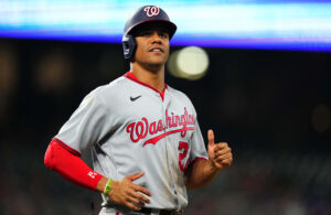 Washington Nationals left fielder Juan Soto jogs to first base with a smile after drawing a walk against the Colorado Rockies