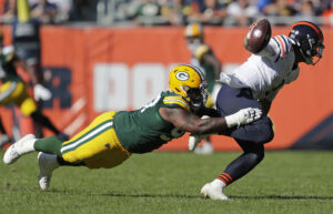 Green Bay Packers defensive tackle Kenny Clark (left) tackles Chicago Bears quarterback Justin Fields