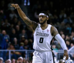 Providence center Nate Watson raises three fingers in the air after making a three-point basket