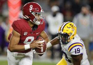 Alabama Crimson Tide quarterback Bryce Young scrambles away from LSU Tigers linebacker Mike Jones Jr.