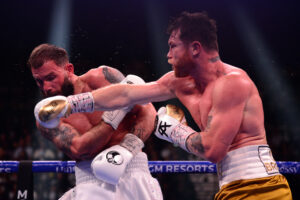 Canelo Alvarez (right) connects with a right cross to the face of Caleb Plant box during their undisputed super middleweight world championship boxing match 