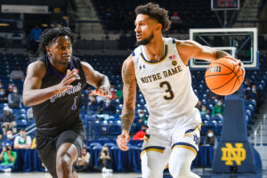 Notre Dame Fighting Irish guard Prentiss Hubb (right) dribbles the ball while defended by High Point Panthers guard John-Michael Wright (left)