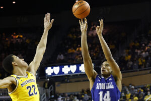 Seton Hall Pirates guard Jared Rhoden (right) shoots over Michigan Wolverines forward Caleb Houstan (left) in a game at Michigan