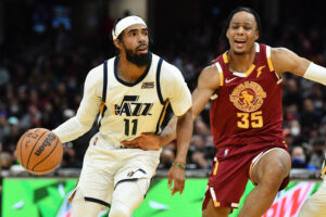 Utah Jazz guard Mike Conley (left) drives to the basket against Cleveland Cavaliers forward Isaac Okoro (right)