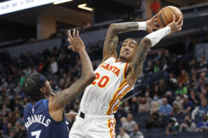 Atlanta Hawks forward John Collins (right) grabs the basketball away from Minnesota Timberwolves forward Jaden McDaniels (left)