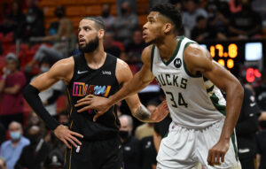 Miami Heat forward Caleb Martin (left) and Milwaukee Bucks forward Giannis Antetokounmpo (right) prepare to grab a rebound during a free-throw attempt