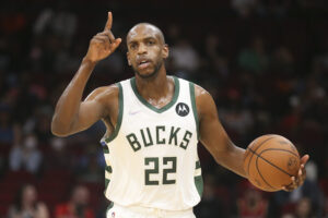 Milwaukee Bucks forward Khris Middleton holds the basketball while calling out a play against the Houston Rockets