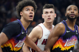 Phoenix Suns forwards Cameron Johnson (left) and Mikal Bridges (right) attempt to box out Miami Heat guard Tyler Herro (center) during a free-throw attempt