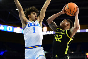 Oregon Ducks guard Jacob Young (right) rises up to shoot the basketball while being defended by UCLA Bruins guard Jules Bernard (left) during a Pac-12 basketball game