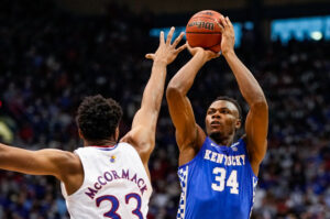 Kentucky Wildcats forward Oscar Tshiebwe (right) shoots over Kansas Jayhawks forward David McCormack (left)