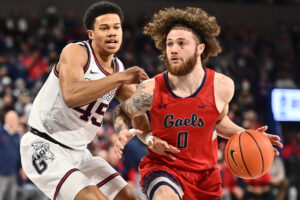 St. Mary's Gaels guard Logan Johnson (right) dribbles the basketball and drives the lane against Gonzaga Bulldogs guard Rasir Bolton (left) during a West Coast Conference basketball game