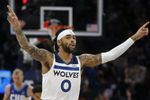 Minnesota Timberwolves guard D'Angelo Russell raises up both arms as he celebrates his three point basket against the Charlotte Hornets