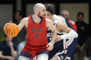 St. Mary's Gaels guard Tommy Kuhse (foreground) dribbles the ball while being defended by Gonzaga Bulldogs guard Andrew Nembhard during a West Coast Conference basketball game