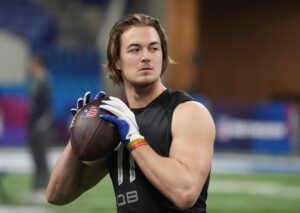 Pittsburgh quarterback Kenny Pickett grasps the football with both hands and looks to throw downfield while going through drills during the 2022 NFL Scouting Combine