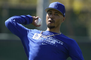 Los Angeles Dodgers outfielder Mookie Betts prepares to throw the baseball with his right hand while warming up during spring training camp