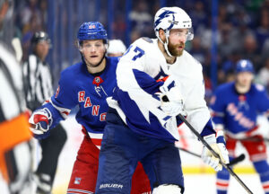 New York Rangers left wing Dryden Hunt (left) defends from behind as Tampa Bay Lightning defenseman Victor Hedman (right) controls the puck (unseen)