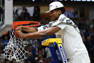 Kansas Jayhawks guard Ochai Agbaji (30) cuts down the nets after the advancing to the Final Four by defeating the Miami Hurricanes 76-50 in the finals of the Midwest regional of the men's college basketball NCAA Tournament at United Center in Chicago on Sunday, March 27, 2022.