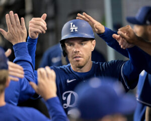 Los Angeles Dodgers first baseman Freddie Freeman (5) is greeted in the dugout after scoring a run in the third inning against the Los Angeles Angels at Dodger Stadium.