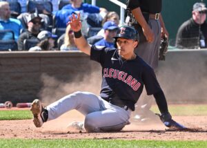 Cleveland Guardians left fielder Steven Kwan (38) slides home, scoring a run during the seventh inning against the Kansas City Royals at Kauffman Stadium.