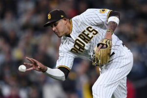 San Diego Padres third baseman Manny Machado prepares to field a ground ball bare-handed before throwing to first base to force out Cincinnati Reds first baseman Joey Votto (not pictured)