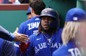 Toronto Blue Jays first baseman Vladimir Guerrero Jr. is congratulated by teammates in his dugout after scoring on an infield fly ball against the Boston Red Sox