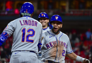 New York Mets shortstop Francisco Lindor (right, back turned) greets smiling pinch hitter Dominic Smith (right) after both runners scored on a single against the St. Louis Cardinals