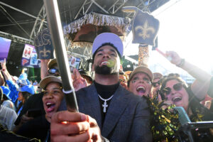 Ohio State wide receiver Chris Olave, front, celebrates with fans after being selected as the eleventh overall pick to the New Orleans Saints during the first round of the 2022 NFL Draft at the NFL Draft Theater in Las Vegas.