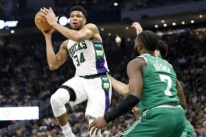 Milwaukee Bucks forward Giannis Antetokounmpo (left) passes the ball under pressure form Boston Celtics guard Jaylen Brown (right) during the second quarter during game three of the second round for the 2022 NBA playoffs at Fiserv Forum.