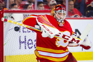 Calgary Flames goaltender Jacob Markstrom raises his stick with his right hand to make a save against the Dallas Stars during a 2022 Stanley Cup Playoffs game