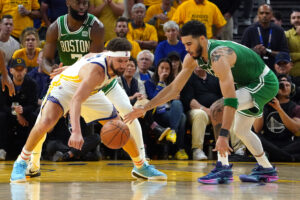 Boston Celtics forward Jayson Tatum, right, and Golden State Warriors guard Klay Thompson, left, battle for a loose ball June 2, 2022, in San Francisco.