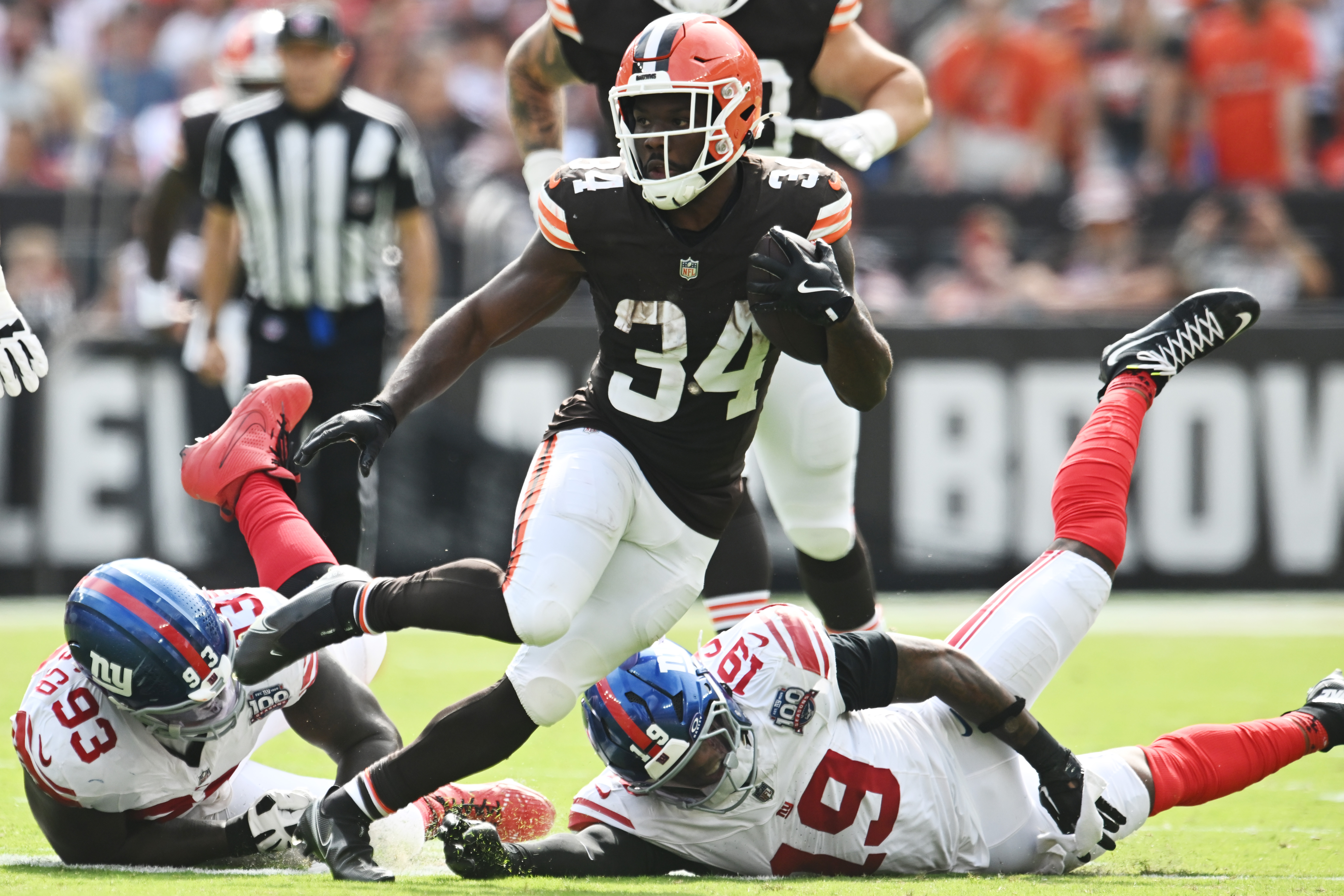 Sep 22, 2024; Cleveland, Ohio, USA; Cleveland Browns running back Jerome Ford (34) runs between New York Giants defensive tackle Rakeem Nunez-Roches (93) and linebacker Isaiah Simmons (19) during the second half at Huntington Bank Field.