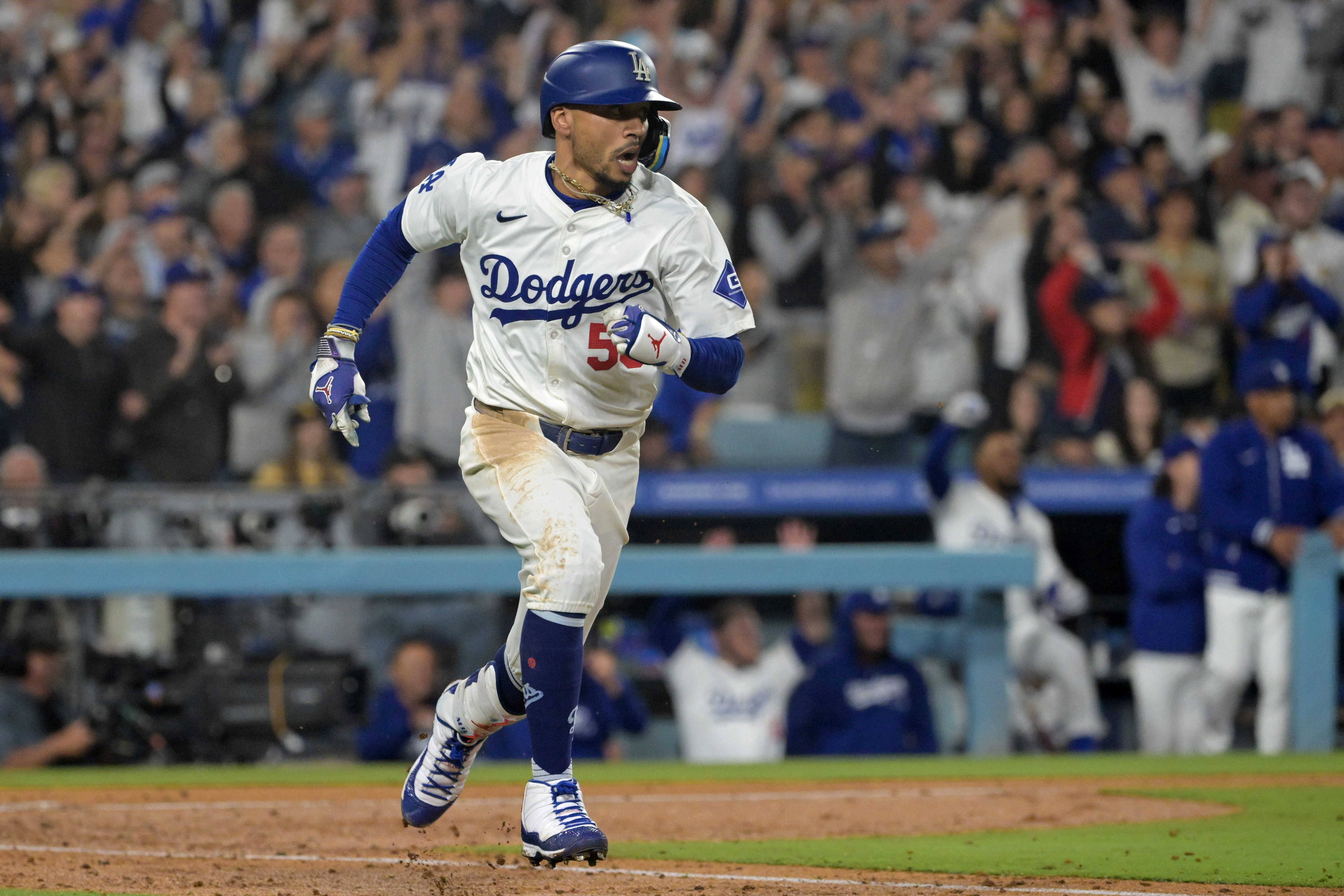 Sep 26, 2024; Los Angeles, California, USA; Los Angeles Dodgers shortstop Mookie Betts (50) hits a RBI single in the seventh inning against the San Diego Padres at Dodger Stadium.