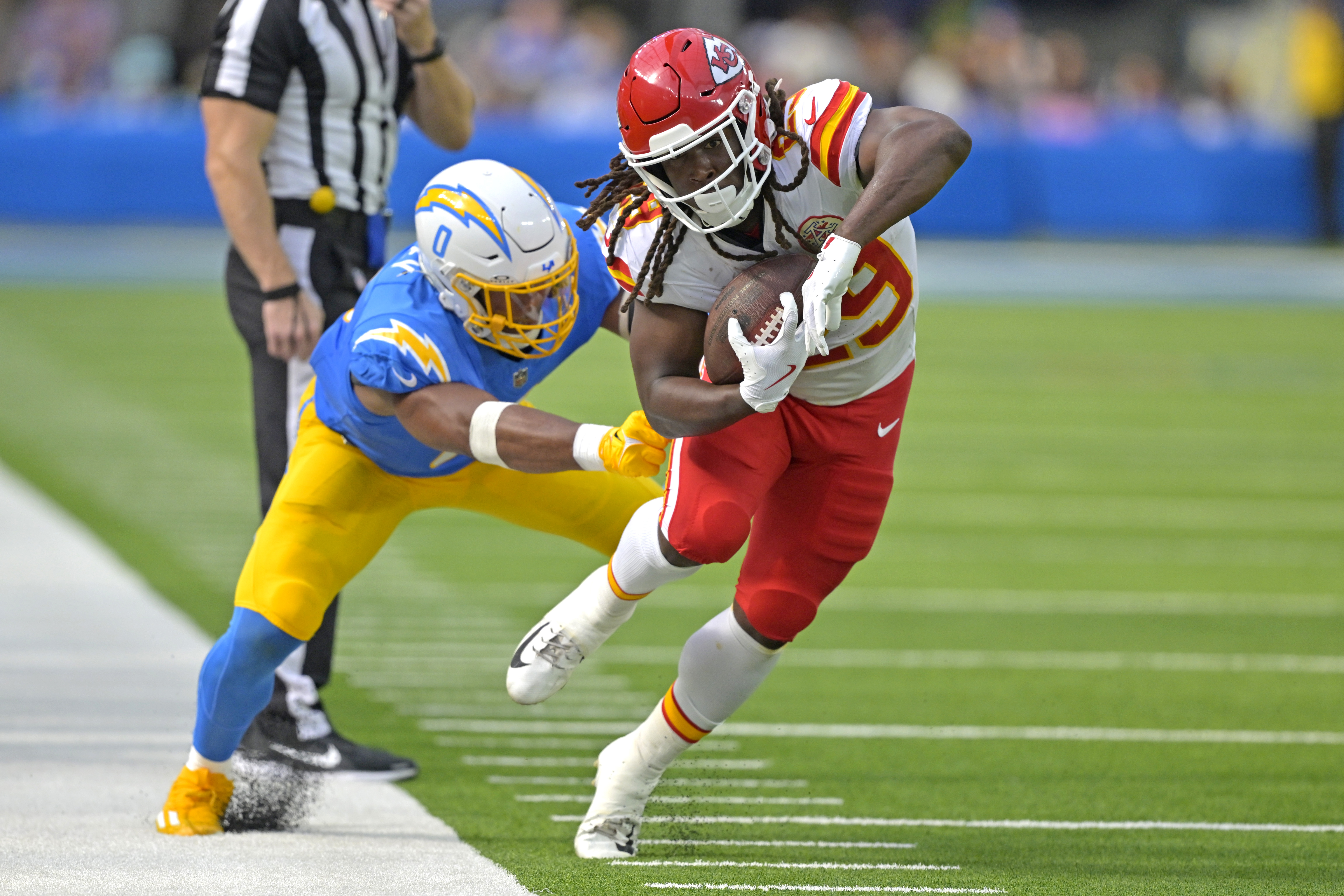 Sep 29, 2024; Inglewood, California, USA; Kansas City Chiefs running back Kareem Hunt (29) runs for a first down before he is forced out of bounds by Los Angeles Chargers linebacker Daiyan Henley (0) in the second half at SoFi Stadium.